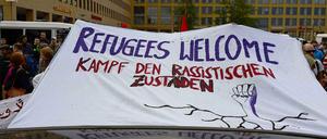 Mit einem großen Banner wollen sie die Flüchtlinge willkommen heißen. 