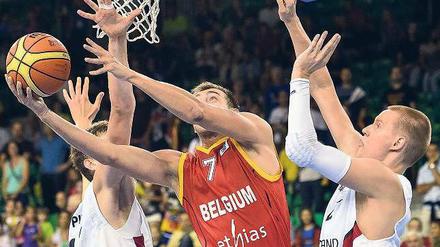 Sind so lange Arme. Die deutschen Nationalspieler Tibor Pleiß (l.) und Robin Benzing (r.) kommen gegen den routinierten Belgier Axel Hervelle zu spät. Foto: AFP