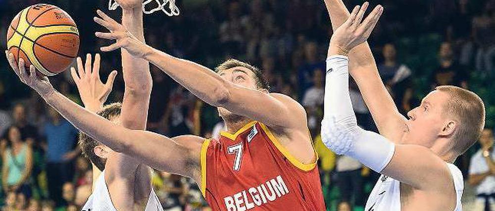 Sind so lange Arme. Die deutschen Nationalspieler Tibor Pleiß (l.) und Robin Benzing (r.) kommen gegen den routinierten Belgier Axel Hervelle zu spät. Foto: AFP