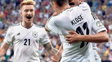 Das Tor zum Jubiläum. Miroslav Klose feiert seinen Treffer, Thomas Müller (r.) ist erster Gratulant vor Marco Reus (l.). Foto: Reuters