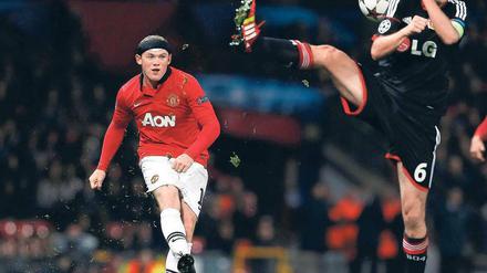 Hart getroffen. Wayne Rooney kommt in dieser Szene nicht an Simon Rolfes vorbei. Trotzdem war er der auffälligste Spieler auf dem Platz – nicht nur wegen seines Stirnbands. Foto: Reuters