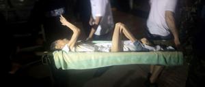 Ein Mann wird in Sicherheit gebracht, nachdem Tropensturm "Manuel" sein Haus wegspülte.