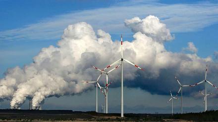 Nach der Wahl wird die Debatte über eine Reform des Erneuerbare-Energien-Gesetzes (EEG) ernsthaft geführt werden. Denn dass es Reformbedarf gibt, bezweifelt niemand. Das Foto zeigt das Braunkohlekraftwerk Jänschwalde mit Windrädern davor.