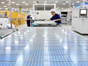 Zwei Arbeiter sind in einer Fabrik des chinesischen Solarpanel-Herstellers Longi Green Energy Technology zu sehen.