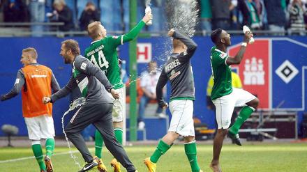 Party beim Rivalen: Werders Spieler feiern auf dem rasen des Volksparkstadions den Auswärtssieg.