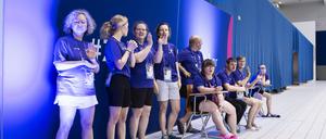 Volunteers helfen bei den Schwimmwettbewerben der Special Olympics. 