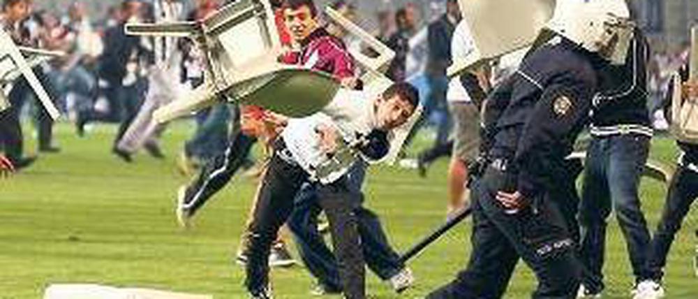 Sturm auf dem Platz. Hunderte Fans lieferten sich Kämpfe mit der Polizei. Foto: dpa