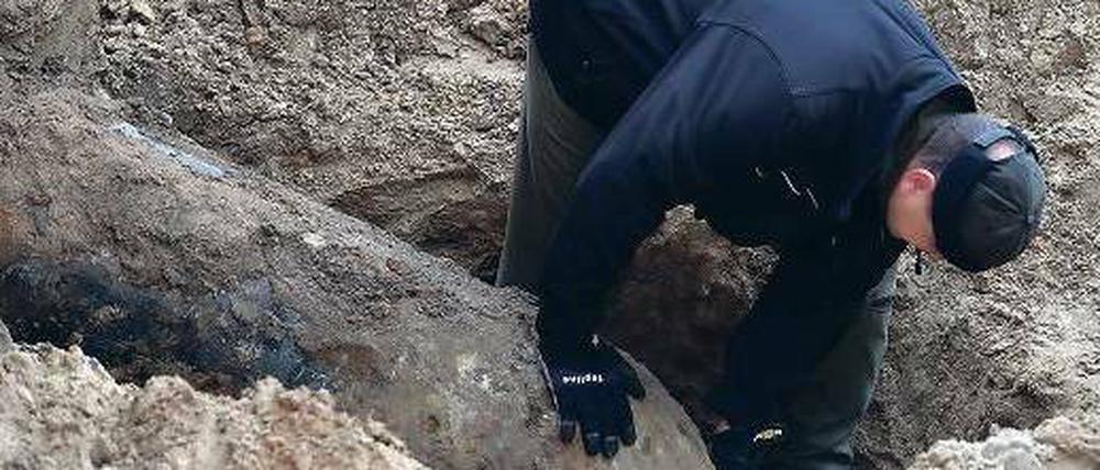 Fund mit Folgen. Ein Polizeifeuerwerker untersucht die Bombe auf der Baustelle in der Hubertusallee in Schmargendorf. Foto: dpa