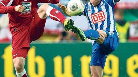 Pokal ist nicht Herthas Bühne. Zwar mühte sich Nico Schulz (rechts) gegen Chris Löw, aber wieder einmal vergebens. Die Berliner verloren in Kaiserlautern deutlich und schieden gegen den Zweitligisten bereits in der zweiten Runde aus. Foto: dpa