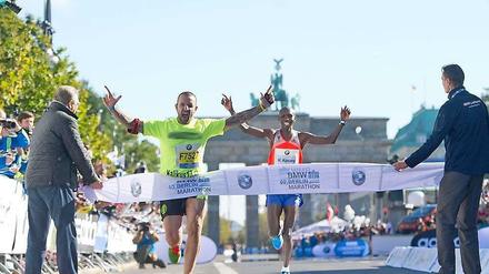 Huch, wer ist das denn? Nicht der neue Weltrekordhalter Wilson Kipsang Kiprotich riss das Zielband, sondern ein Flitzer. Der Störenfried betrat die Strecke kurz vor dem Ziel und durchquert es vor dem Kenianer. Innensenator Frank Henkel (CDU) links schaute nur verdutzt zu. 