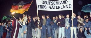 Einheitsgeschichte: 1989 auf der Mauer beim Brandenburger Tor.