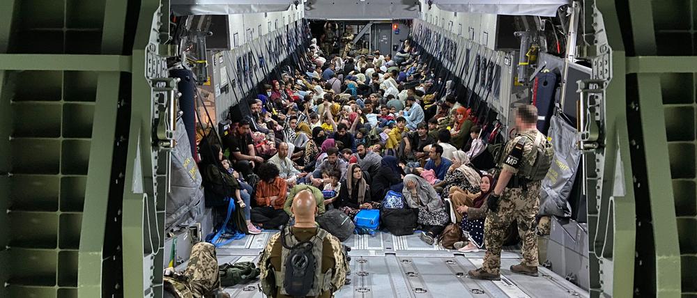 Geflüchtete sitzen in einem Airbus A400M der Bundeswehr. Die Bundeswehr hat weitere deutsche Staatsbürger und afghanische Ortskräfte aus Kabul evakuiert. +++ dpa-Bildfunk +++