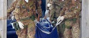 Tod vor Lampedusa. Italienische Soldaten tragen die Leiche eines Opfers. Foto: AFP