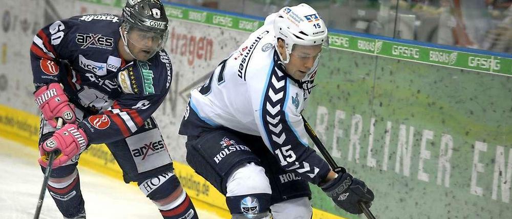 Bär gegen Kühlschrank. Mads Christensen (l.) von den Eisbären Berlin im Zweikampf mit Duvie Westcott von den Hamburg Freezers.