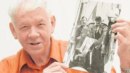Der 70-jährige Adolf Herbst zeigt ein Foto von seiner Rettung. 