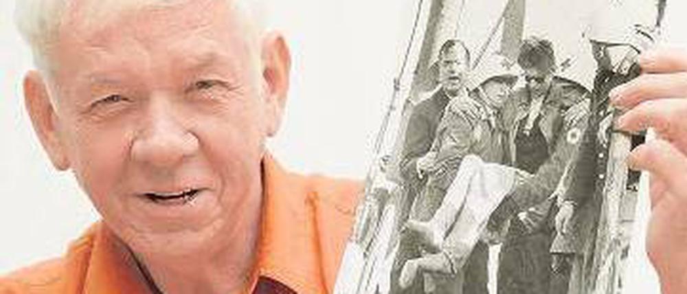 Der 70-jährige Adolf Herbst zeigt ein Foto von seiner Rettung. 
