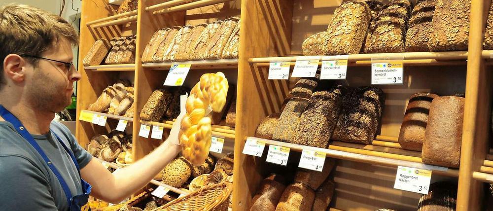 Reichhaltiges Sortiment. Naturkostfachverkäufer Cedric Quentin füllt die Regale der trotz Insolvenz weiter geführten Bäckerei in der Ufa-Fabrik.