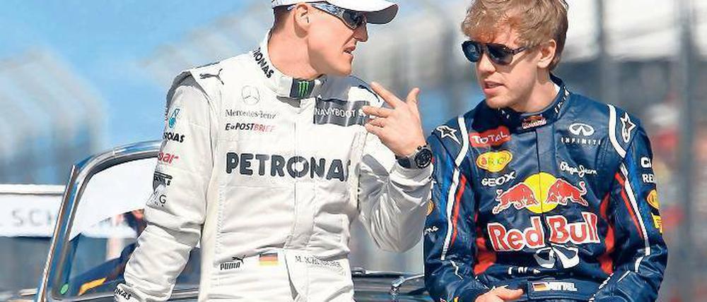Rot ist deine Farbe! Michael Schumacher (l.) will Sebastian Vettel zu Ferrari lotsen. Foto: dpa