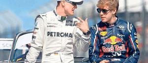 Rot ist deine Farbe! Michael Schumacher (l.) will Sebastian Vettel zu Ferrari lotsen. Foto: dpa