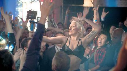 Lady Gaga filmt sich beim Bad inmitten tanzender Fans. 