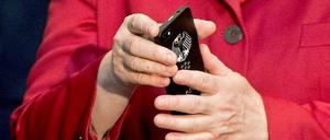 Auf der Computermesse CeBit begutachtet Merkel ein Handy mit Bundesadler. Dass ihr eigenes abgehört werden könnte, hatte sie sicher nicht vermutet.