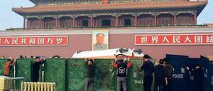 Verdeckt: Der Ort des Unfalls auf dem Platz des Himmlischen Friedens in Peking wird von Arbeitern und Polizisten abgesperrt. Auf dem Tiananmen-Platz hatten Sicherheitskräfte im Juni 1989 ein Massaker an friedlichen Demonstranten verübt. Foto: Ed Jones/AFP