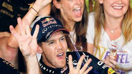 Vier Finger für ein Halleluja. Sebastian Vettel jubelt nach seinem Sieg beim Großen Preis von Indien im Kreise seines Teams Red Bull über seinen vierten Weltmeistertitel hintereinander. Foto: dpa