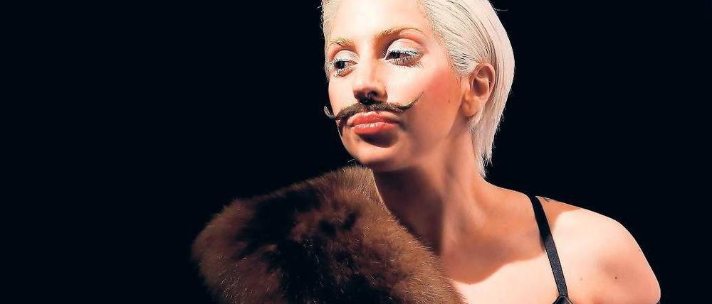Der Bart ist dran. So ging Lady Gaga im Berghain auf die Bühne. Mehrere hundert Anhänger empfingen den Popstar schon am Mittwoch am Potsdamer Platz – der lag dann in Tiergagarten. Eine Gruppe Jugendlicher war extra aus Polen angereist und hatte vorm Hotel Ritz Carlton übernachtet. Fotos: Kai-Uwe Heinrich, dpa