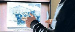 In der Ausstellung zur ehemaligen Inspektion der Konzentrationslager (IKL) in Oranienburg können Besucher an einem virtuellen Regal Originaldokumente und Fotos betrachten. 