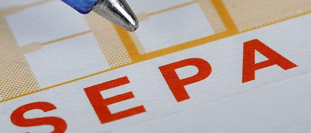 Ein Kugelschreiber ist neben einem Überweisungsträger mit der Aufschrift "Sepa" zu sehen.