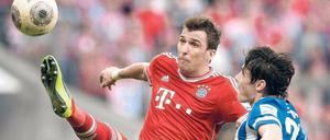 In Bedrängnis gebracht. Herthas Mittelfeldspieler Nico Schulz verhindert, dass Bayern-Stürmer Mario Mandzukic den Ball in Ruhe annehmen kann. Am Tag nach dem 2:3 pendelten die Gefühle der Hertha-Spieler zwischen Stolz und Trauer. Foto: AFP