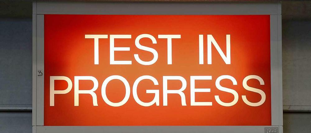 Ein rotes Schild mit der Aufschrift "Test in Progress"