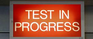 Ein rotes Schild mit der Aufschrift "Test in Progress"
