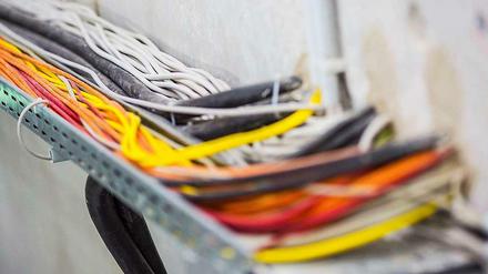 Bunte Kabel führen in eine Wand