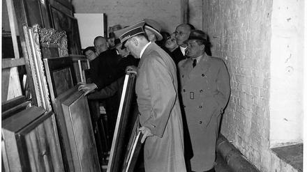 Adolf Hitler besichtigt beschlagnahmte Kunstwerke am 13. Januar 1938 im Berliner Viktoriaspeicher, hinter ihm Joseph Goebbels. Die konfiszierten Bilder aus der Wohnung des Kunsthändlersohns Cornelius Gurlitt dürfen aus rechtlichen Gründen nicht online gezeigt werden. 