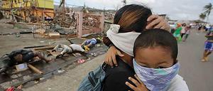 Eine Mutter versucht, ihr Kind vor Infektionskrankheiten zu schützen, während in Tacloban noch die Leichen auf der Straße liegen.