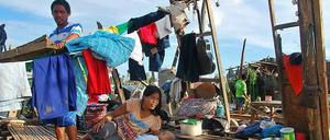 Eine Familie in den Trümmern ihres Hauses. Viele Menschen wollen so schnell wie möglich zurück, um zu retten, was zu retten ist.