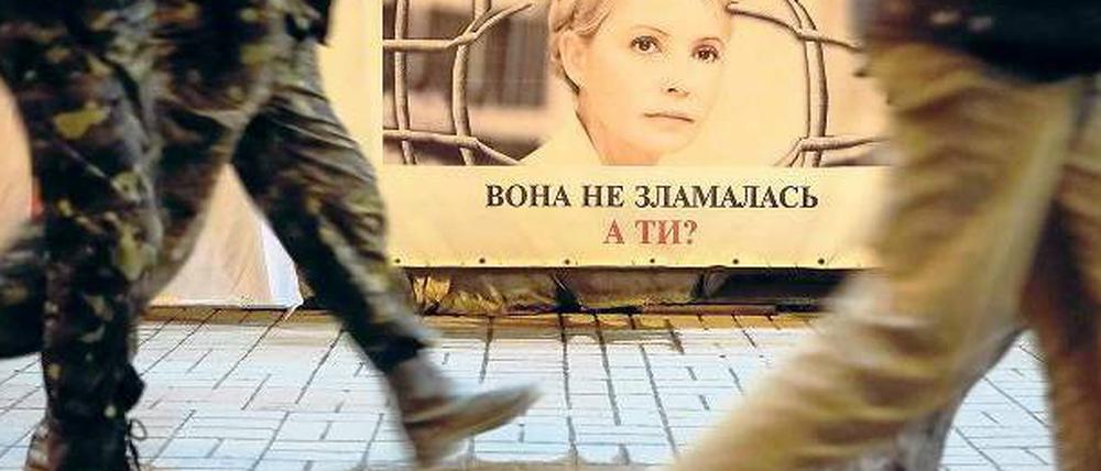 In Kiew gehen Menschen an einem Plakat mit dem Bild von Julia Timoschenko vorbei. 