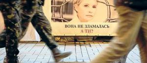 In Kiew gehen Menschen an einem Plakat mit dem Bild von Julia Timoschenko vorbei. 