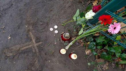 Blumen, Tee- und Grablichter neben einem in den Boden geritztem Kreuz in Eichwalde (Brandenburg). Am Vortag war an dieser Stelle ein 14-jähriges Mädchen erstochen worden.
