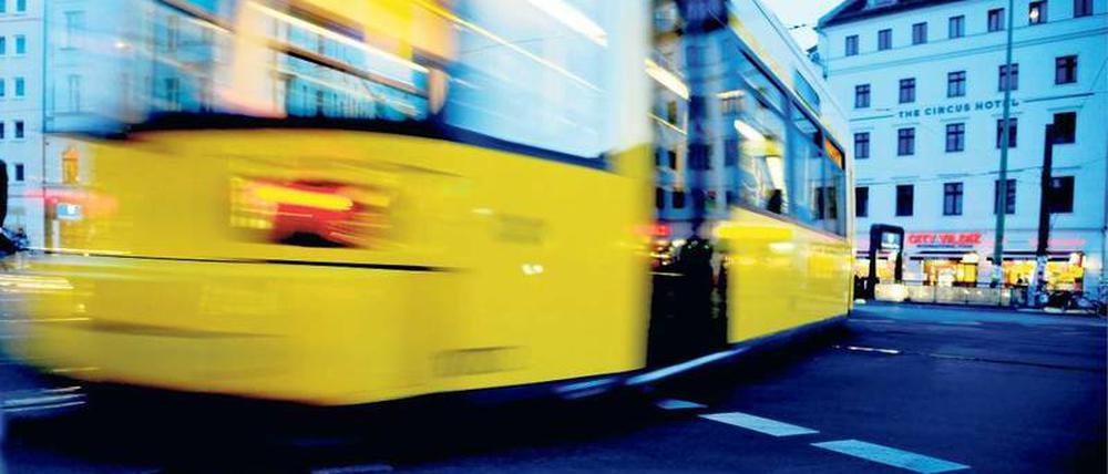 Eine gelbe Berliner Straßenbahn fährt über den Rosenthaler Platz. 