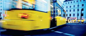 Eine gelbe Berliner Straßenbahn fährt über den Rosenthaler Platz. 
