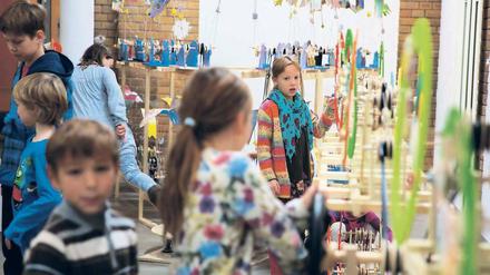Am Rad drehen. Schüler der Grundschule im Blumenviertel in Prenzlauer Berg probieren ihre selbst gebauten Maschinen aus. Foto: Björn Kietzmann