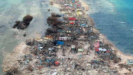 Küste ohne Schutz. Dieses Foto einer vom Taifun verwüsteten Insel in der zentralphilippinischen Provinz Samar zeigt beispielhaft den fehlenden Schutz. Die Mangrovenwälder sind verschwunden, die hellen Flecken im Meer zeigen, dass viele Sedimente in die Seegraswiesen geschwemmt worden sind, und selbst die Korallenriffe etwas weiter draußen sind teilweise mit Sand bedeckt. 