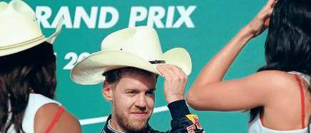 Ich hab’ hier den Hut auf. Vettel schäkert in Austin mit den Grid-Girls. Foto: AFP