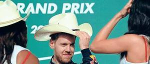 Ich hab’ hier den Hut auf. Vettel schäkert in Austin mit den Grid-Girls. Foto: AFP