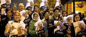 Freundlicher Empfang. Diese Menschen warteten am Flughafen in Teheran auf Irans Außenminister, als der aus Genf zurückkehrte. Sie halten Bilder von Präsident Ruhani in den Händen. 