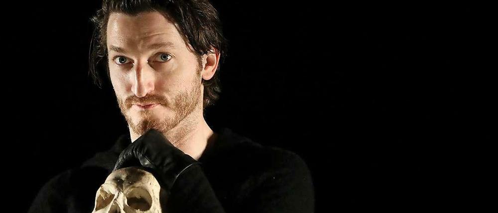 Schauspieler Christopher Nell hält als Hamlet einen Totenkopf in der Hand.