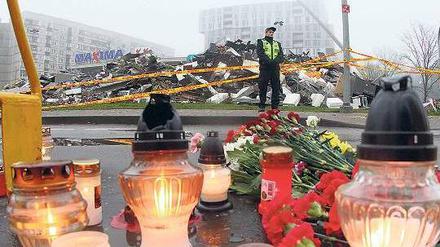 An die Toten erinnern: Vor dem zerstörten Einkaufszentrum in der lettischen Hauptstadt Riga haben Angehörige Kerzen aufgestellt. Foto: AFP