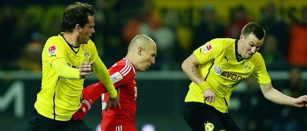 Die Dortmunder Manuel Friedrich (links) und Kevin Großkreutz (rechts) kämpfen mit Arjen Robben vom FC Bayern um den Ball.